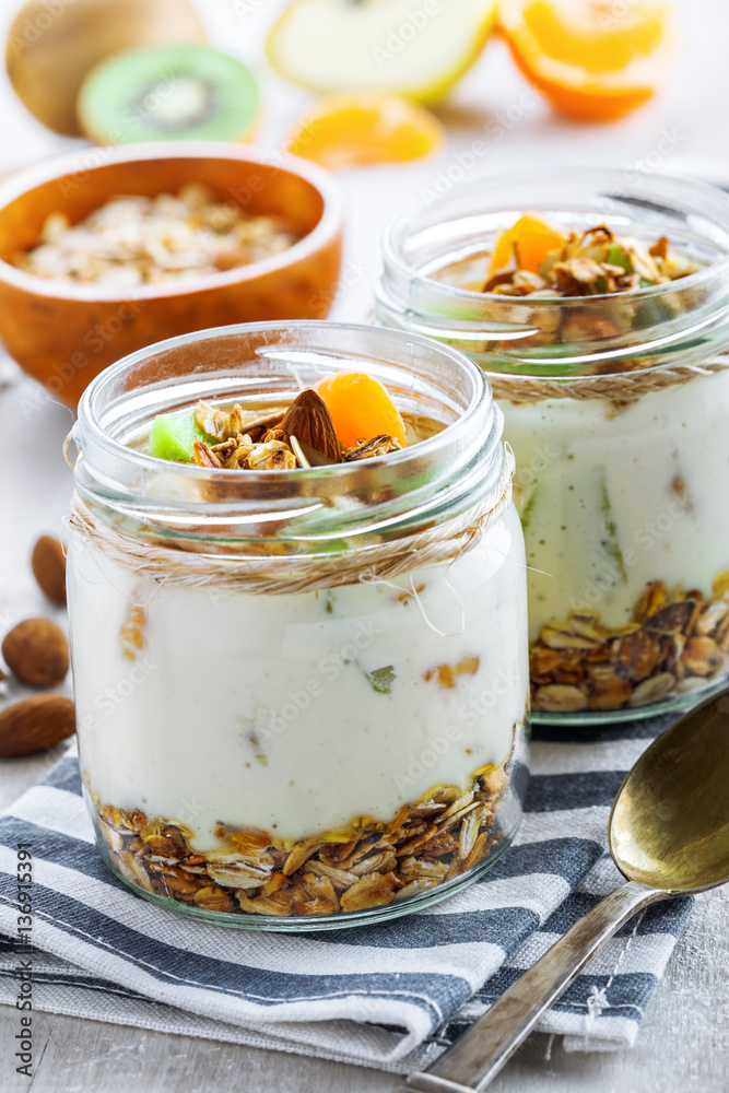 Yogurt, granola and fruits in a jars for delicious breakfast. Traditional American healthy food. Yogurt, granola and fruits in a jars for delicious breakfast. Traditional American healthy food.