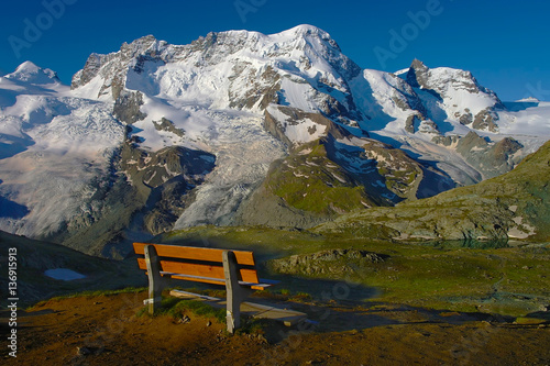Bench view over the alp snowy mountains