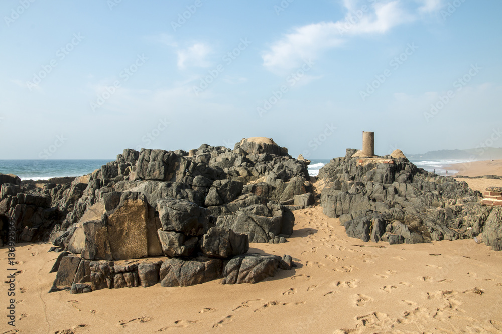 Rocks on Sandy Beach and Blue Coastal Skyline