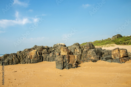 Rocks on Sandy Beach and Blue Coastal Skyline © lcswart
