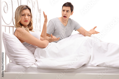 Young couple arguing in bed