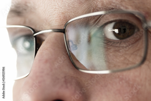 The man's eyes, looking through his glasses closeup.