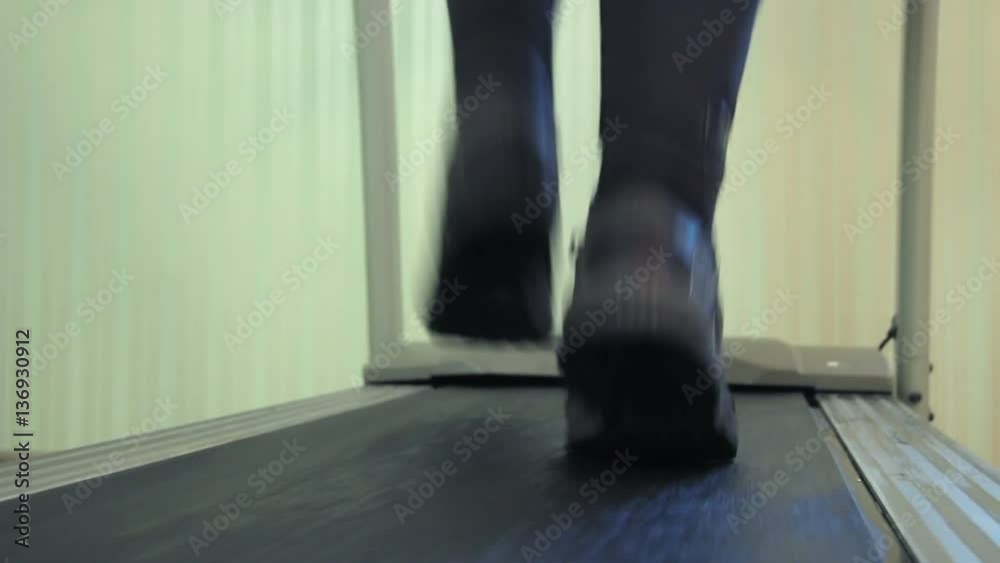 Back view of sportsman feet running on a treadmill Back view of sportsman feet running on a treadmill