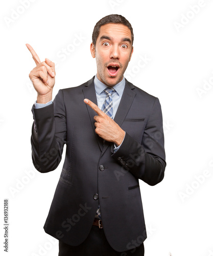 Happy young businessman pointing