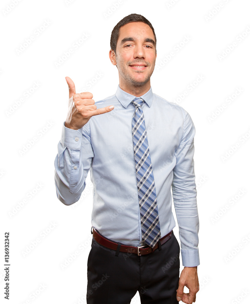 Confident young businessman doing a call gesture Confident young businessman doing a call gesture