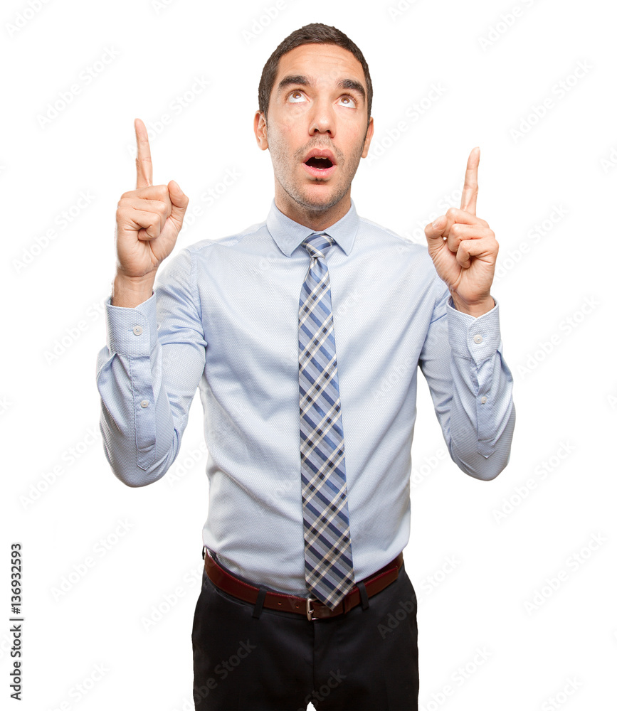 Surprised young businessman pointing up Surprised young businessman pointing up