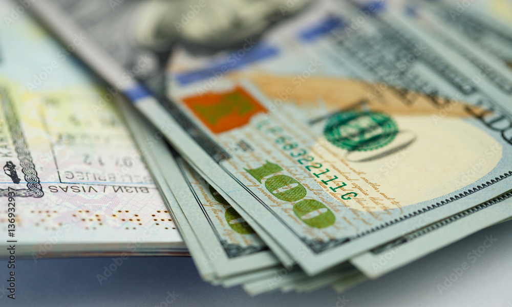 American money is on the top of the opened passport American money is on the top of the opened passport