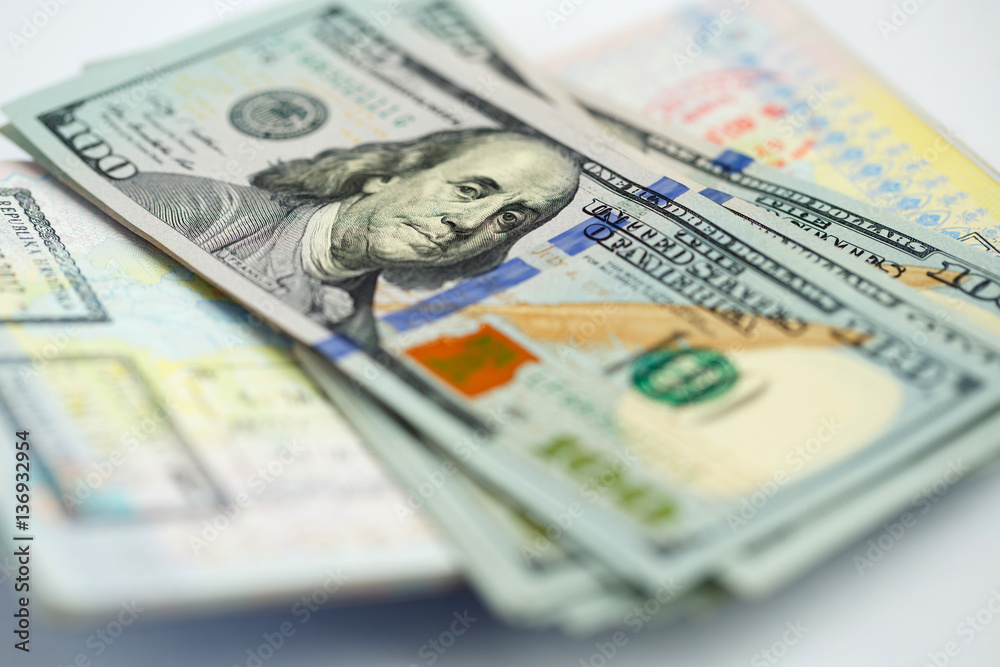 American money is on the top of the opened passport American money is on the top of the opened passport