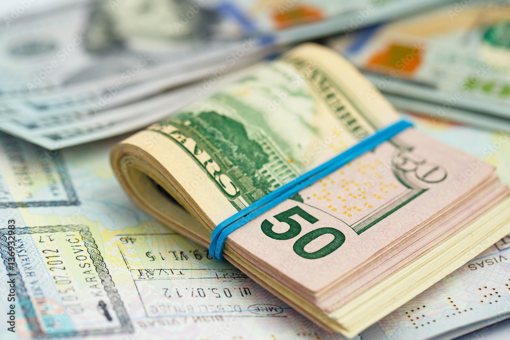American money is on the top of the opened passport American money is on the top of the opened passport