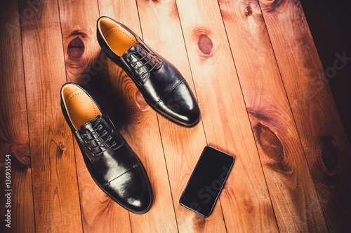 Black leather men's shoes on a wooden background