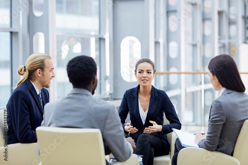 Young managers explaining character features of new tendencies on the market to her colleagues