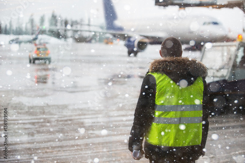 Fotografija Airport manager standing under snowfall