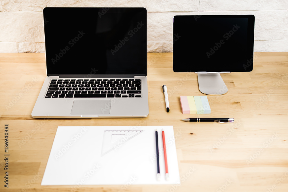 Fototapeta premium view on a wooden desk with a computer tablet and paper