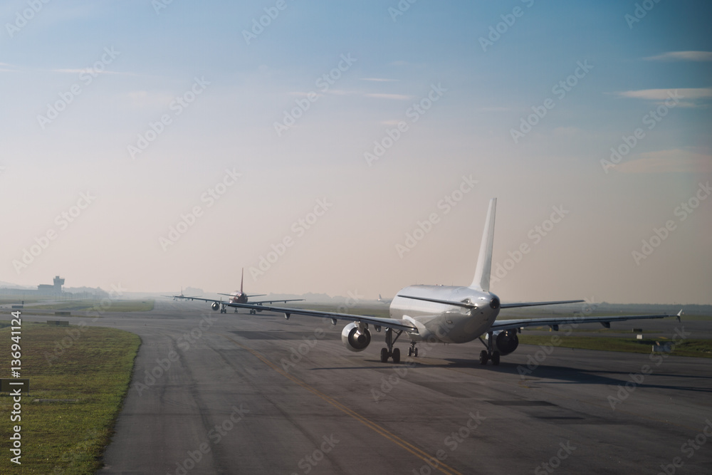 Commercial airplane queue taxiing to take off on runway