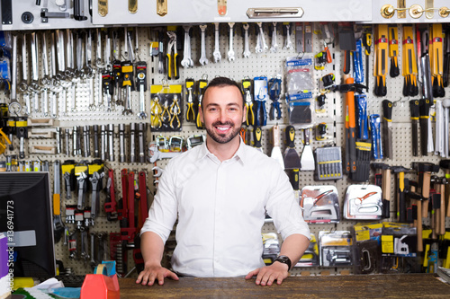 portrait of cheerful man at the cash desk working in tool-ware s photo