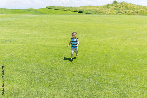 Little kid running on green meadow © Jasmin Merdan