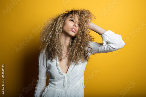 Beautiful woman with hand in her hair contemplates a tough decis