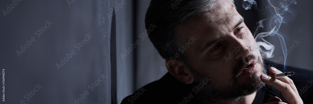 Obraz premium Sad man smoking cigarette