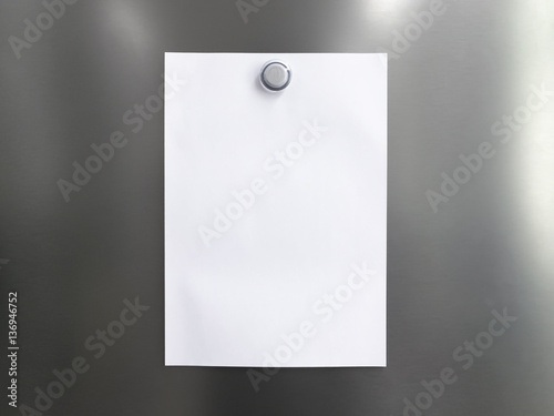 Blank white note paper with magnet clip on metal fridge / refrigerator door for reminder