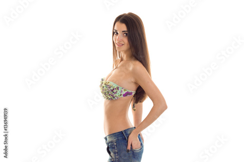 young cute slim brunette lady in swimsuit and jeans shirt with hand on her hip looking at the camera isolated on white background