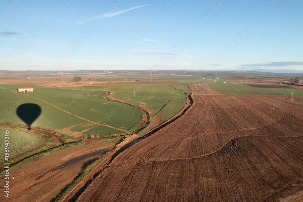 Aerial landscape with the shadow of the hot air balloon from where the image is taken