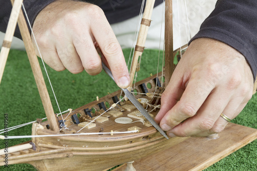Modéliste travaillant sur une maquette de bateau en bois