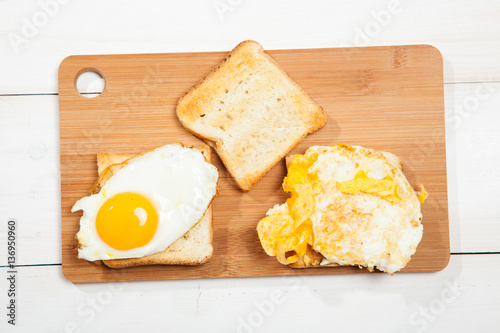 Toasts and egg on a white wooden table