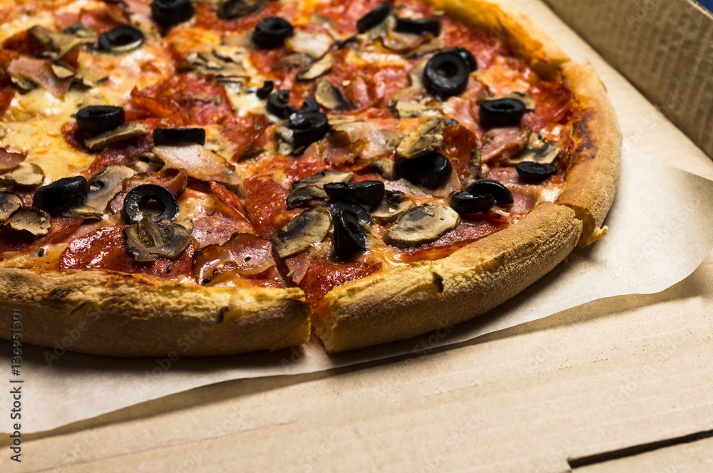 pizza with pepperoni, olives, bacon, mushroom, cheese in the piz