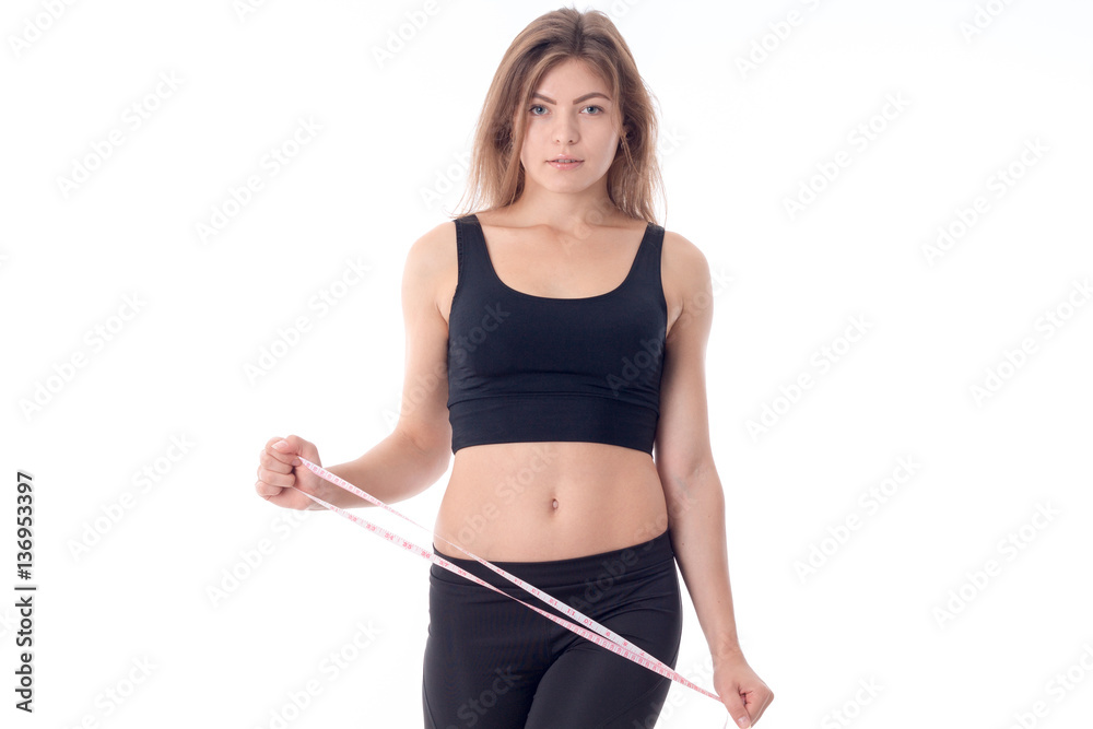 serious athletic girl who looks forward and holding a measuring tape serious athletic girl who looks forward and holding a measuring tape