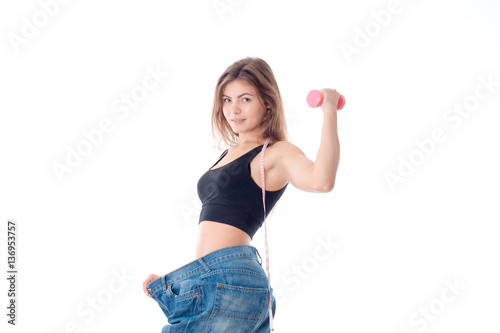 Sports girl wore slacks and shows the biceps on hand isolated white background