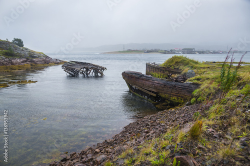 The old flooded wooden boats in water of the Barents Sea, Teribe