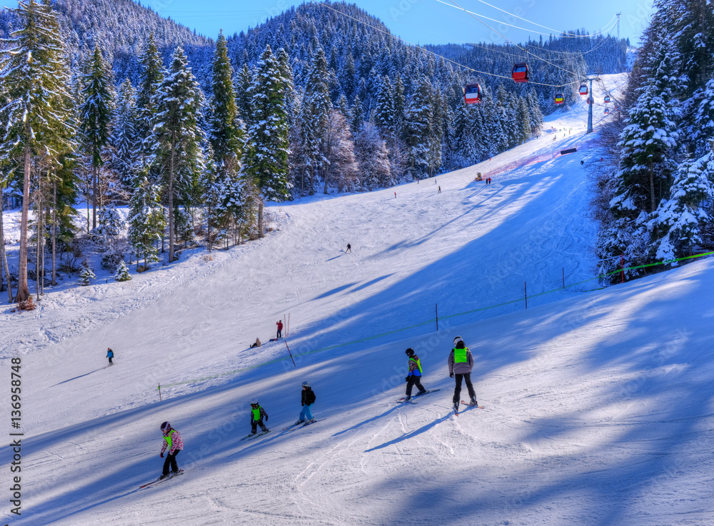 People in vacation practicing ski sport and snowboard outdoor, in a famous place from Poiana Brasov, Romania