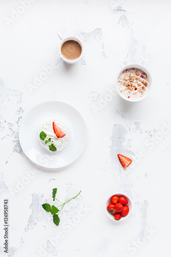 Breakfast with cup of coffee, muesli, sweet dessert, strawberry. Flat lay, top view