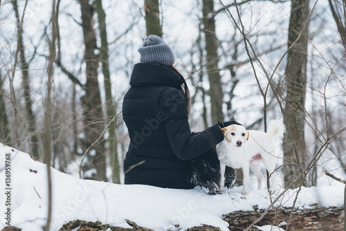 girl sitting on a log in the woods with the dogs