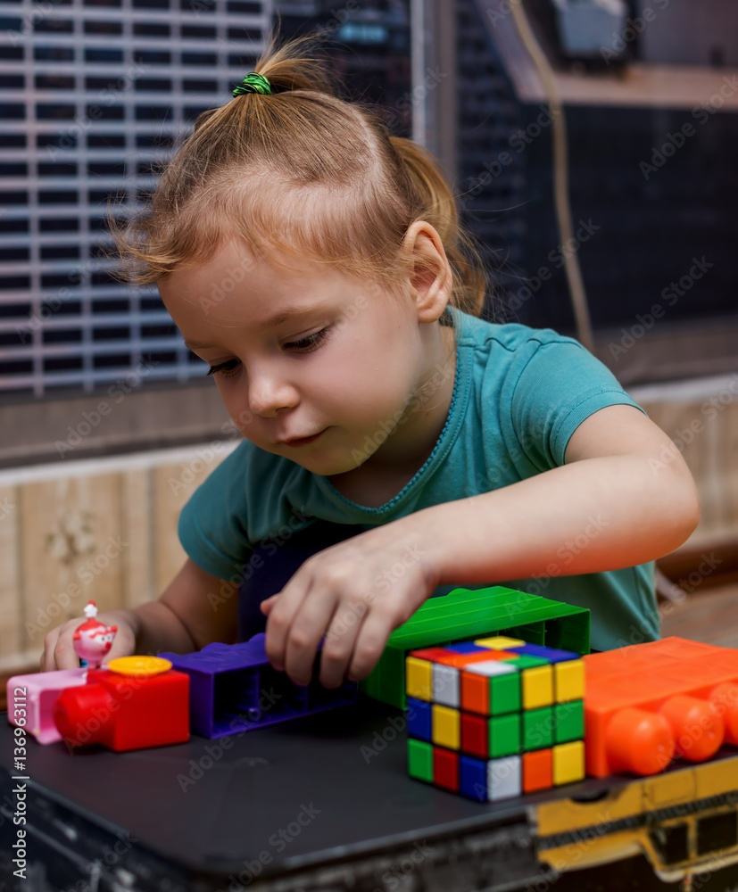 happy little caucasian girl playing with cubes happy little caucasian girl playing with cubes