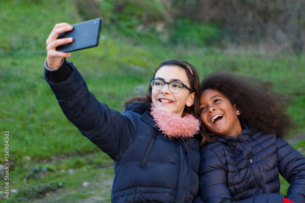 Two girls taking a photo with the mobile Two girls taking a photo with the mobile