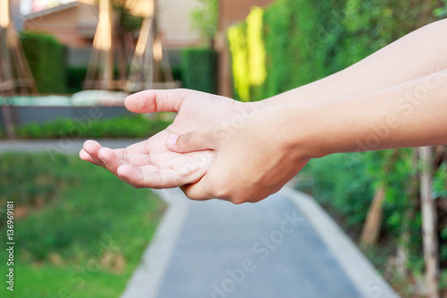 Young woman hands pain in public park concept. © petzshadow