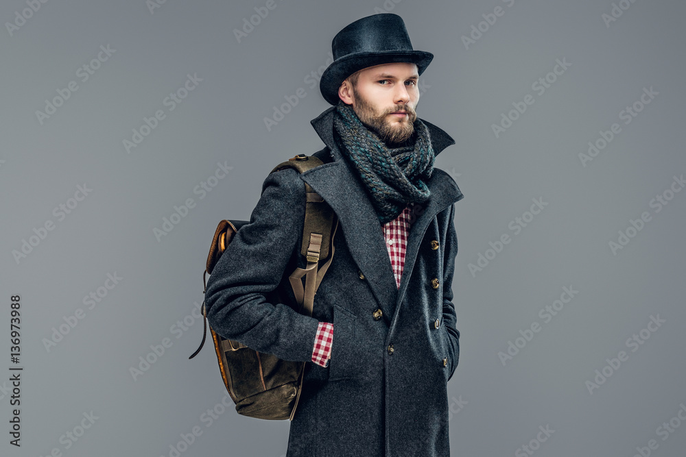 A man in a jacket holds a backpack. A man in a jacket holds a backpack.