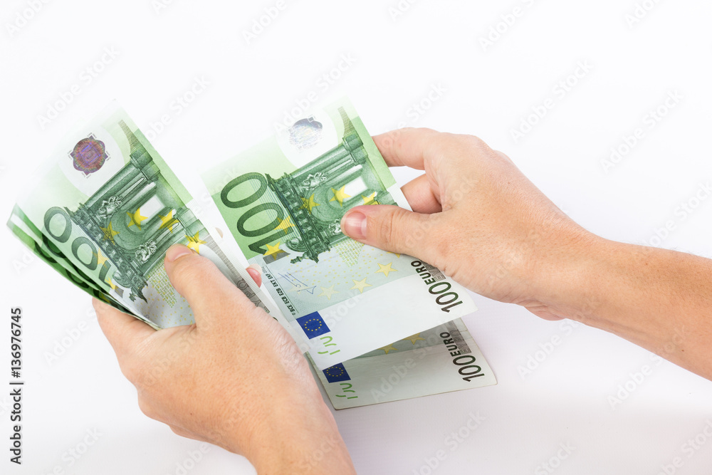 Close up of female hands counting 100 euro banknotes isolated on white background Close up of female hands counting 100 euro banknotes isolated on white background