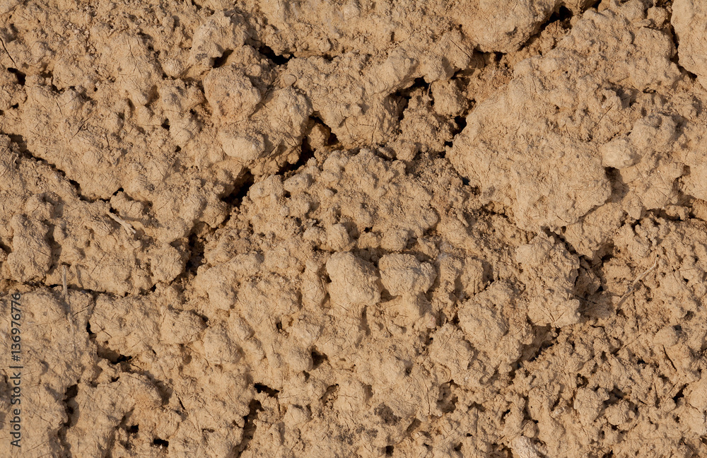 the texture of the clay , the cracks on the surface of the earth , the background is yellow the texture of the clay , the cracks on the surface of the earth , the background is yellow