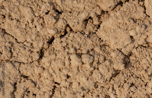 the texture of the clay , the cracks on the surface of the earth , the background is yellow