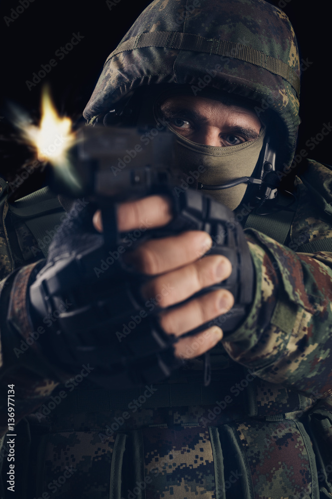 Special forces soldier with gun on dark background