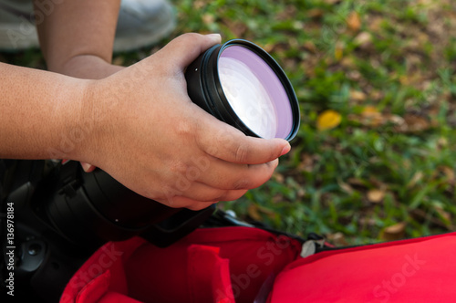 Photographer take it camera and lens telephoto reflection on backpack photo