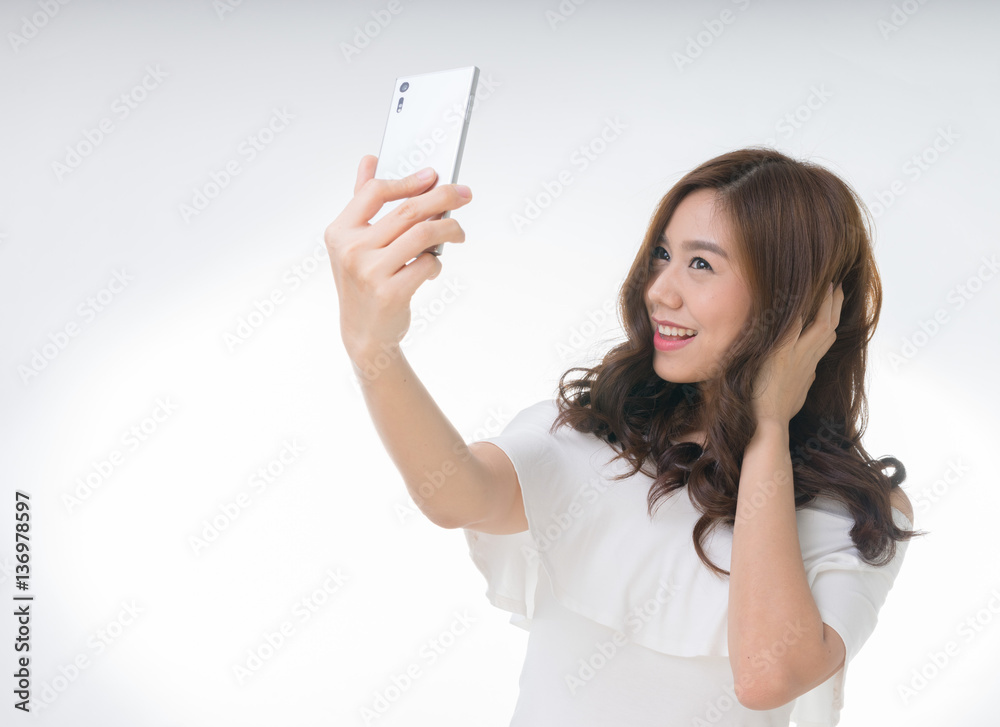 Young attractive asian female taking selfie, on white Young attractive asian female taking selfie, on white