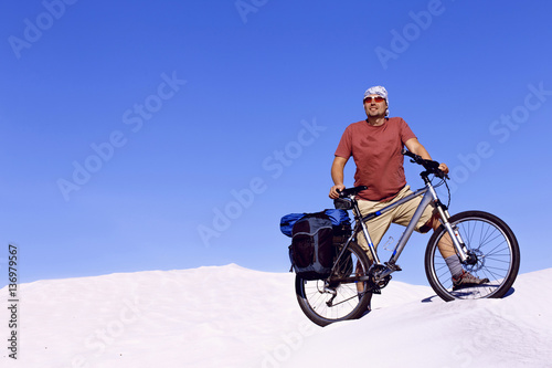 Fototapeta Naklejka Na Ścianę i Meble -  Traveling man on a bicycle in the desert.