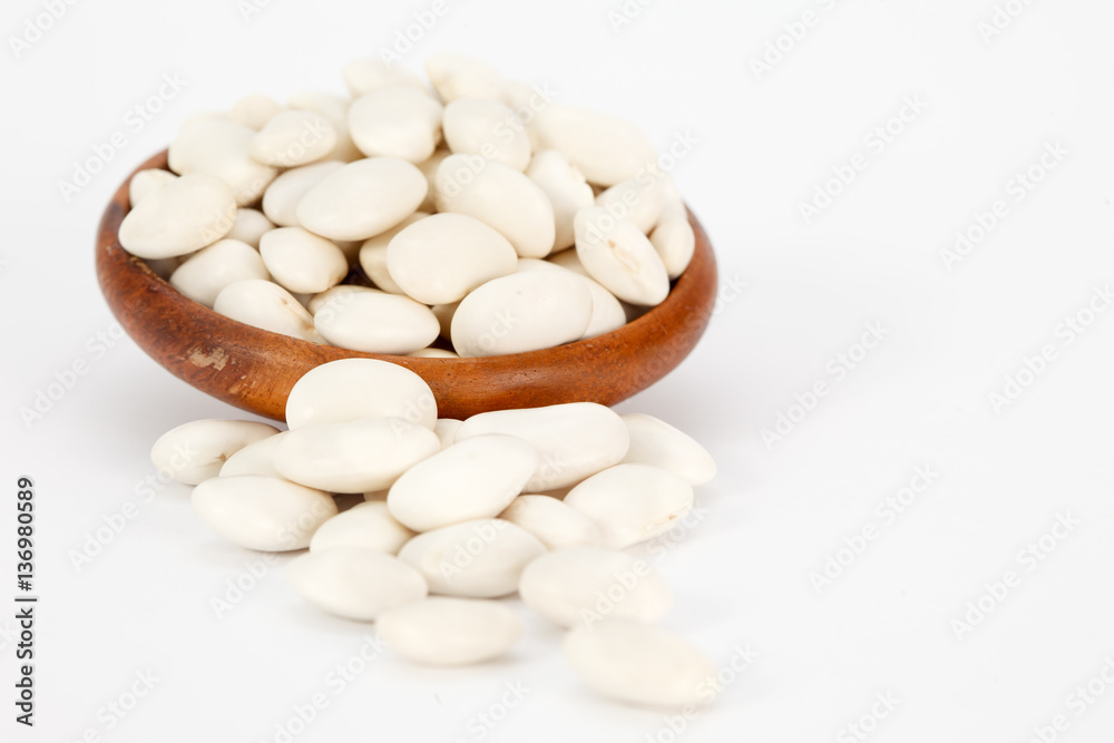 White kidney beans in wooden bowl on white background. Vegan vegetarian healthy food.