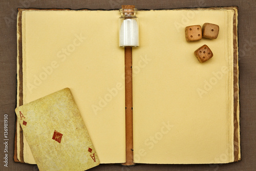 Vintage notepad, jar with something white, playing card and dice photo