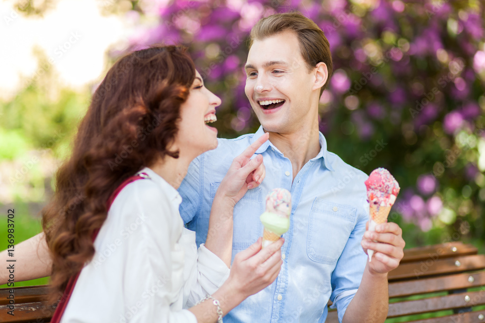 Couple joking and having fun while eating an ice cream Couple joking and having fun while eating an ice cream