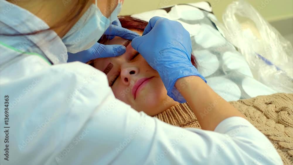 Beautician making permanent makeup of eyelash.