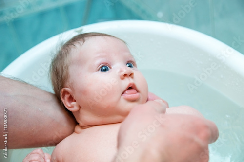 Bathing baby in a baby bath.